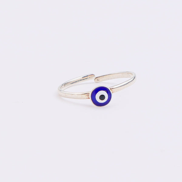 Silver evil eye ring on white surface