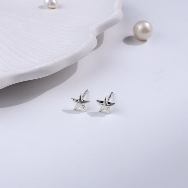 Silver starfish stud earrings on white background