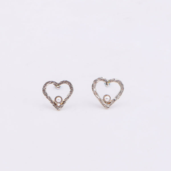 Close-up of silver heart pearl earrings on white background