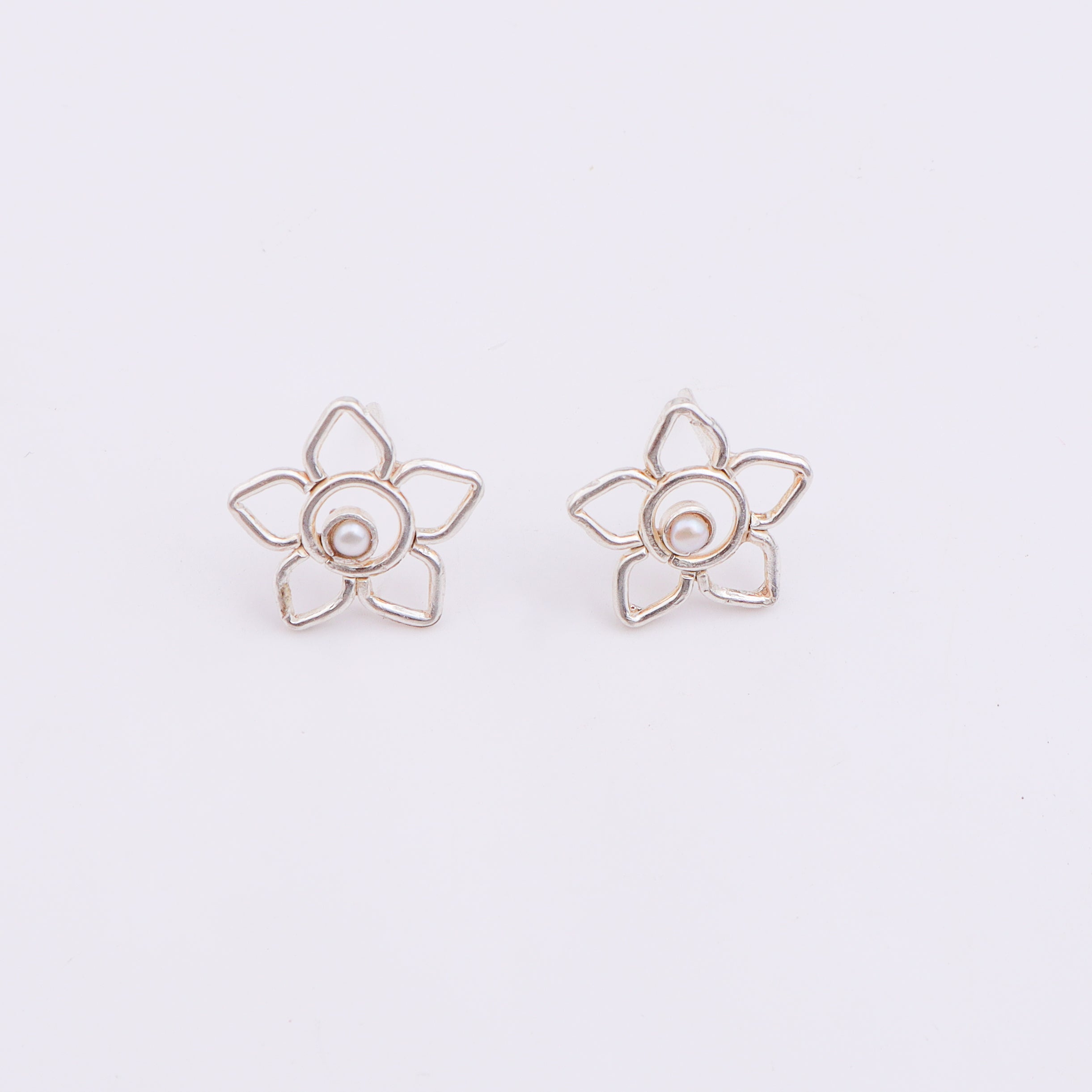 Silver flower earrings on white background