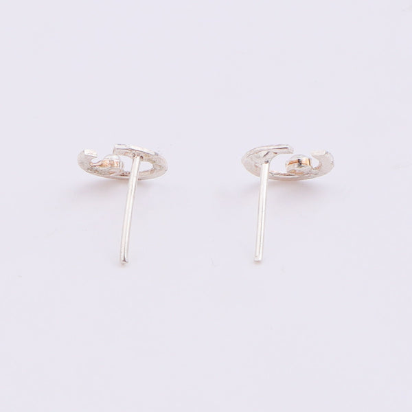 Close-up of silver semi-circle pearl earrings