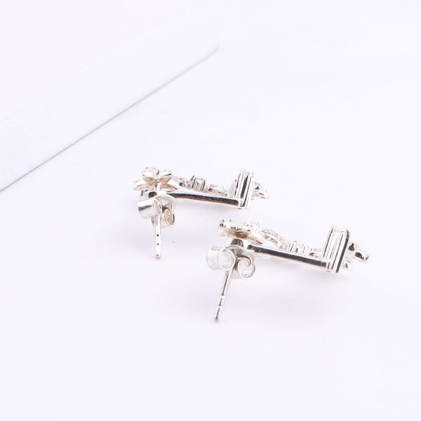 Silver flower vine CZ jacket earrings with cubic zirconia on white surface
