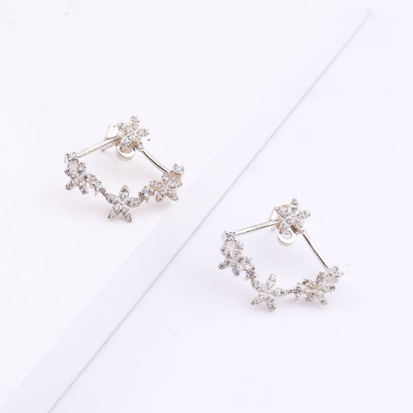 Silver flower vine CZ jacket earrings worn on model's ear