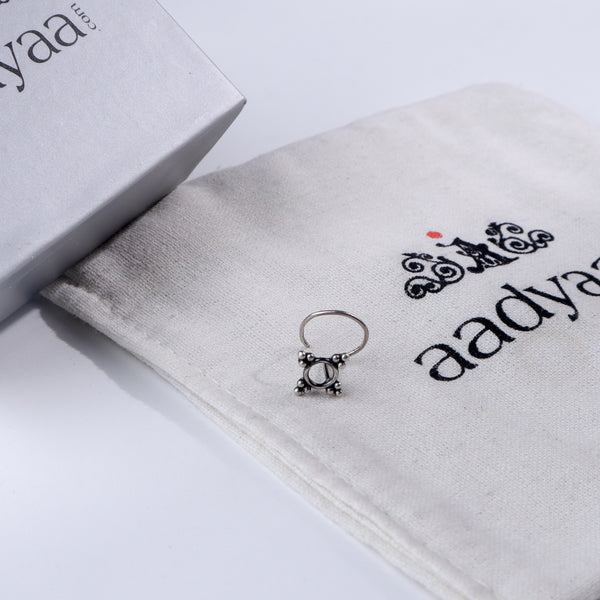 Minimal silver nose pin with decorative design on Aadyaa jewelry pouch