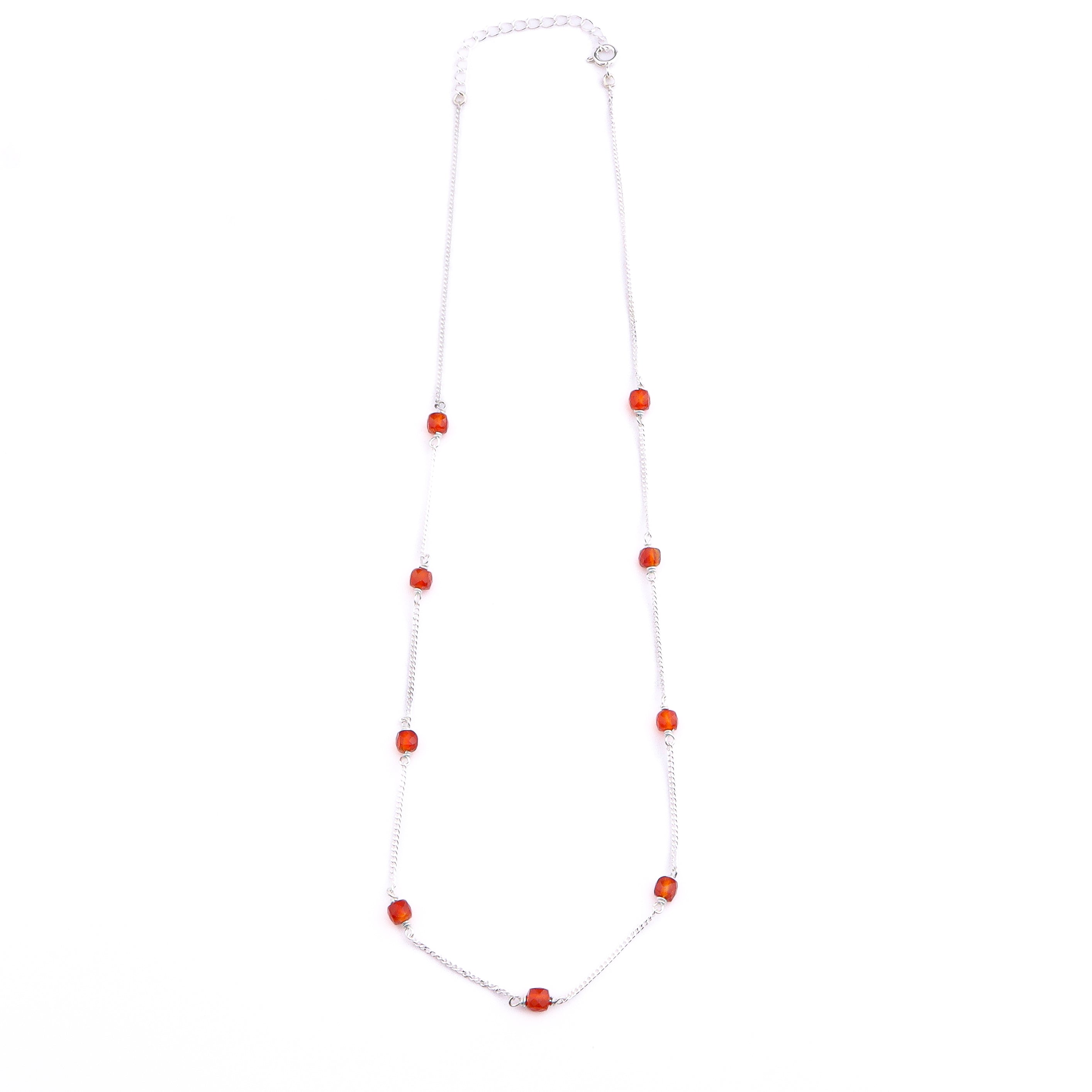 Close-up of silver chain with orange Carnelian beads