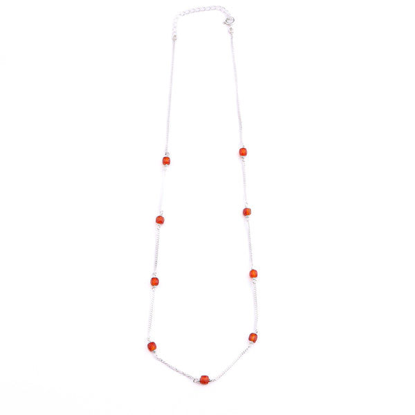 Close-up of silver chain with orange Carnelian beads