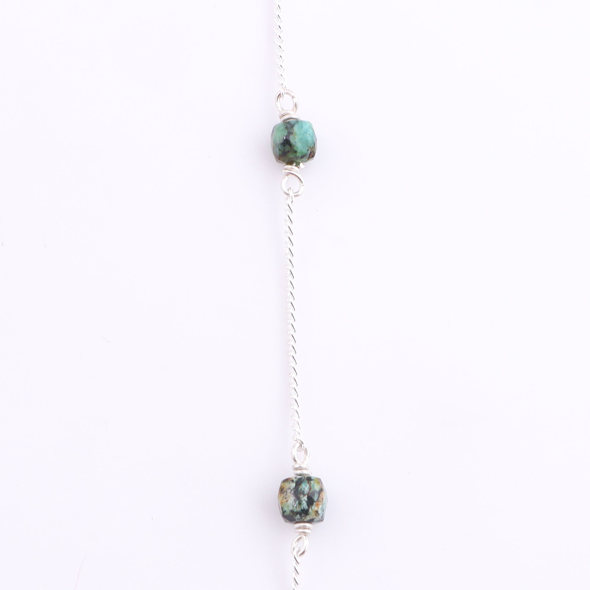 Close-up of silver chain with turquoise bead