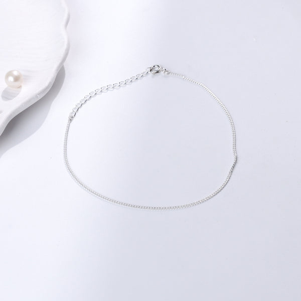 Minimal silver anklet on white background