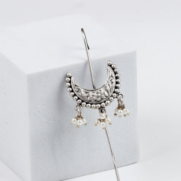 Silver earrings with intricate design and dangling pearl accents
