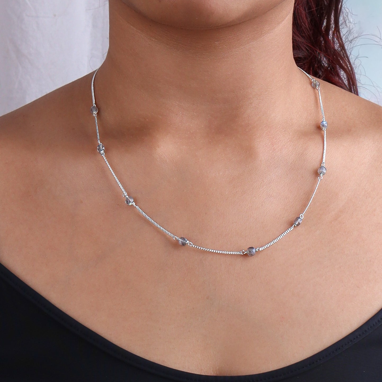 Close-up of silver chain with labradorite beads on model