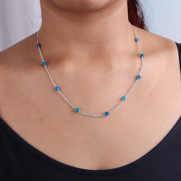 Model wearing silver necklace with blue apatite stones