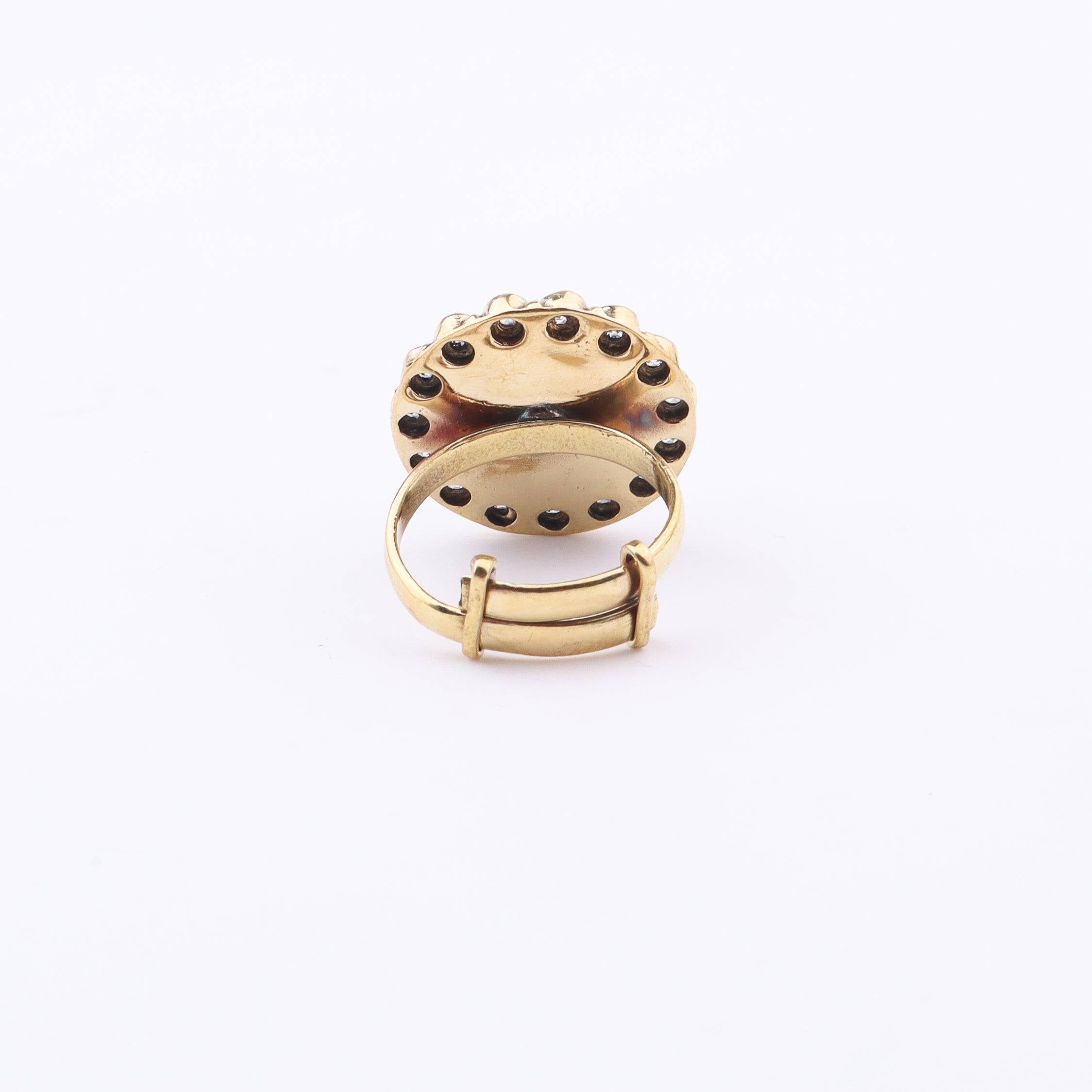 Angled view of a brass fashion ring highlighting its distinctive shape, structure, and polished brass finish