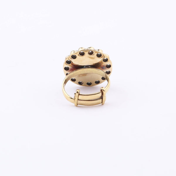 Angled view of a brass fashion ring highlighting its distinctive shape, structure, and polished brass finish