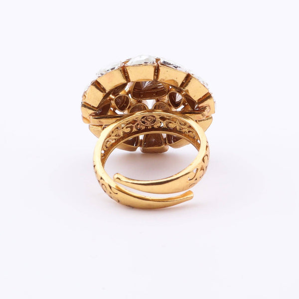 Angled view of a brass fashion ring highlighting its distinctive shape, structure, and polished brass finish