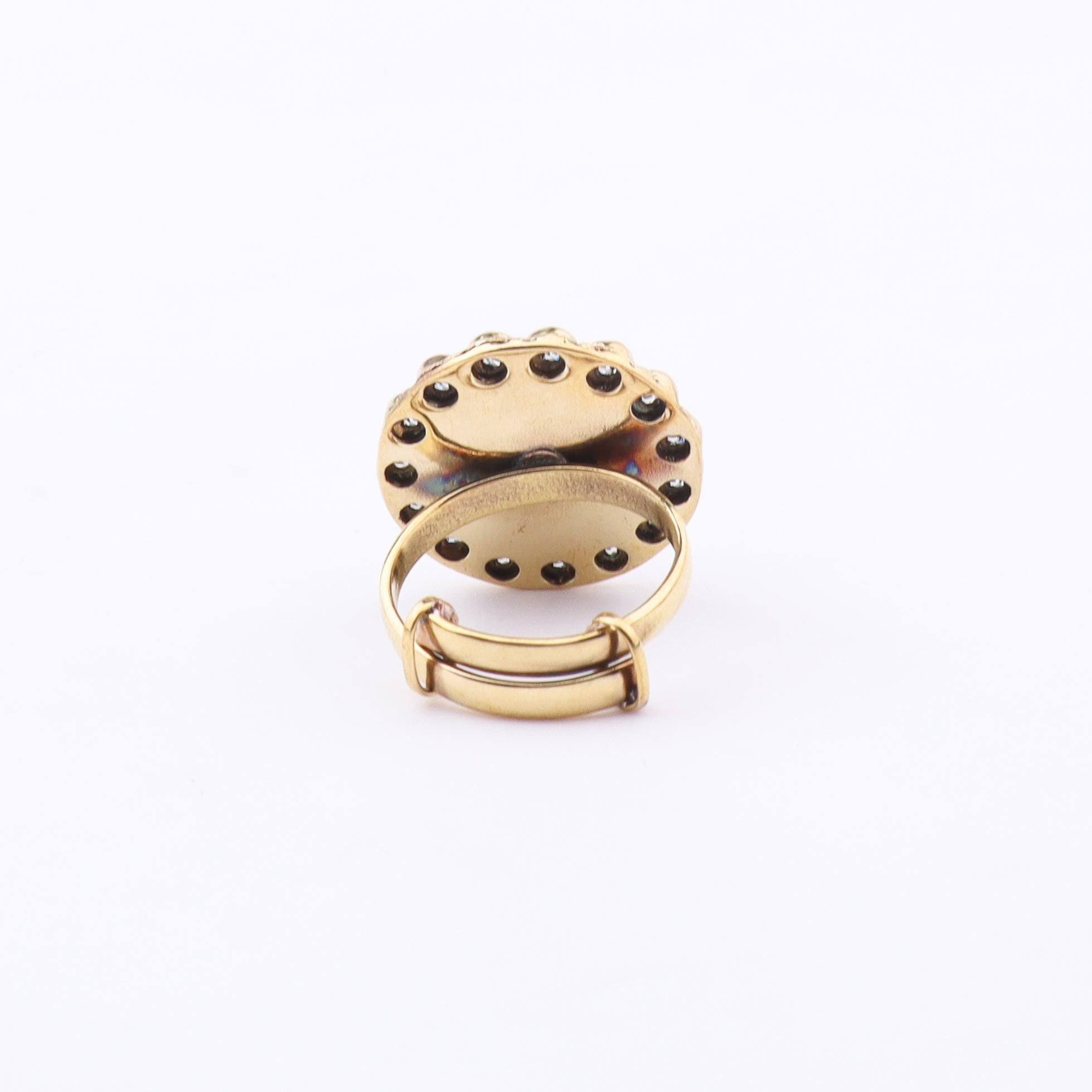 Angled view of a brass fashion ring highlighting its distinctive shape, structure, and polished brass finish