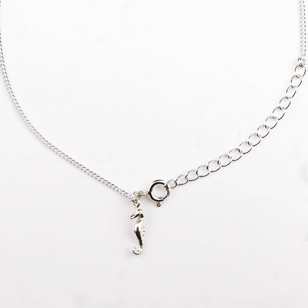 Close-up of silver seahorse charm anklet detailing