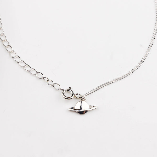 Close-up of silver planet charm anklet detailing