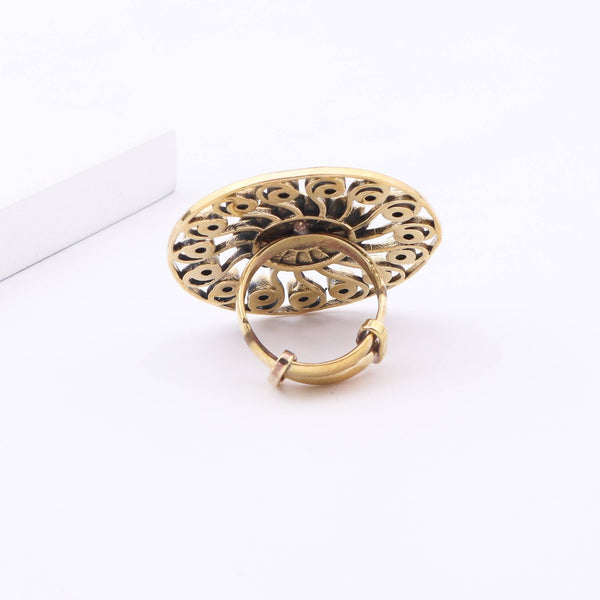 Angled view of a brass fashion ring highlighting its distinctive shape, structure, and polished brass finish
