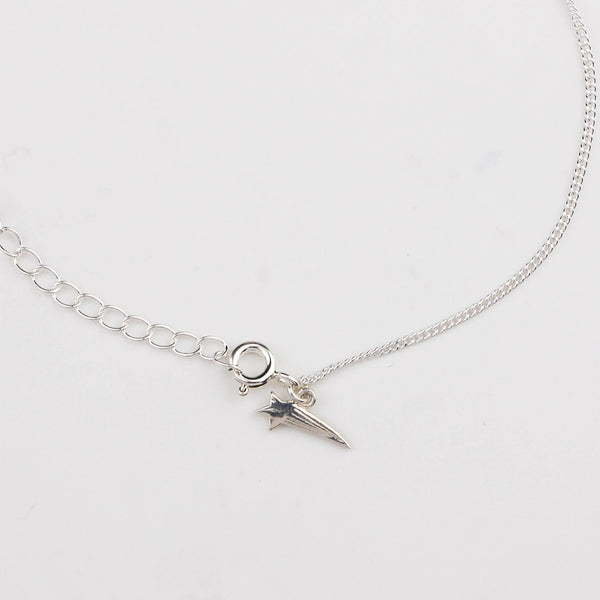 Close-up of silver shooting star charm anklet detailing