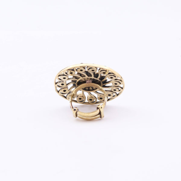 Angled view of a brass fashion ring highlighting its distinctive shape, structure, and polished brass finish