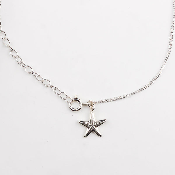 Close-up of silver starfish charm anklet detailing