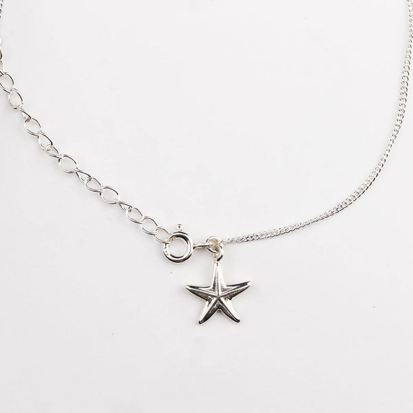 Close-up of silver starfish charm anklet detailing