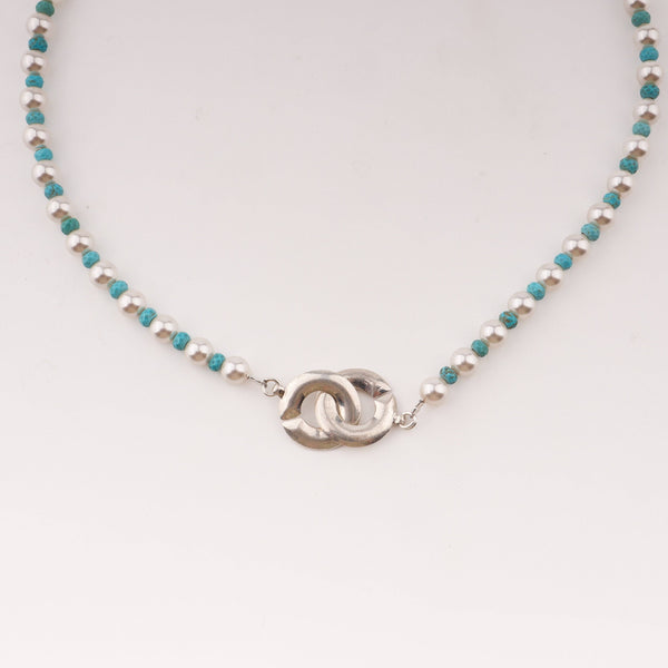 Close-up of pearl and turquoise necklace with infinity lock clasp