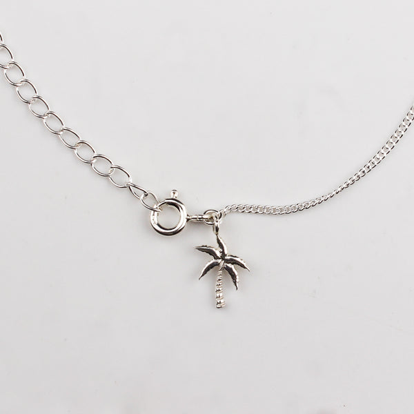Close-up of silver coconut tree charm anklet detailing