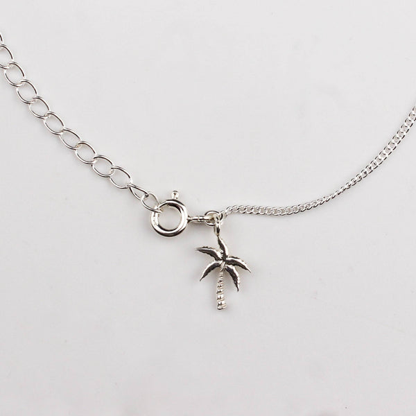 Close-up of silver coconut tree charm anklet detailing