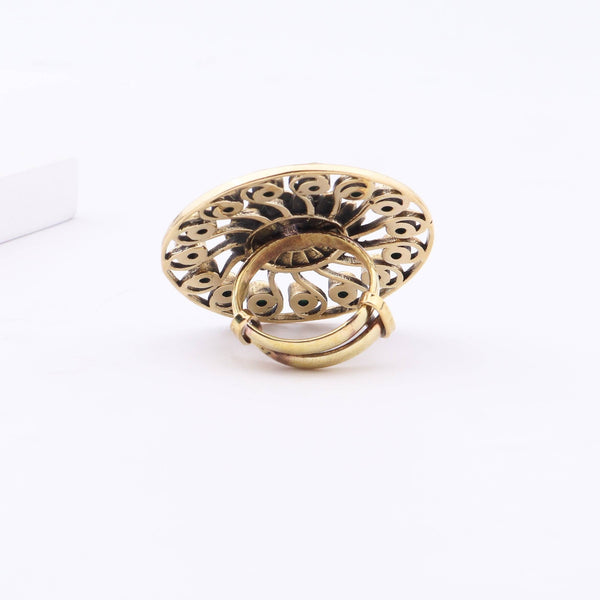 Angled view of a brass fashion ring highlighting its distinctive shape, structure, and polished brass finish