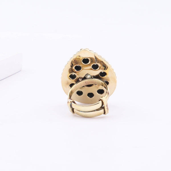 Angled view of a brass fashion ring highlighting its distinctive shape, structure, and polished brass finish
