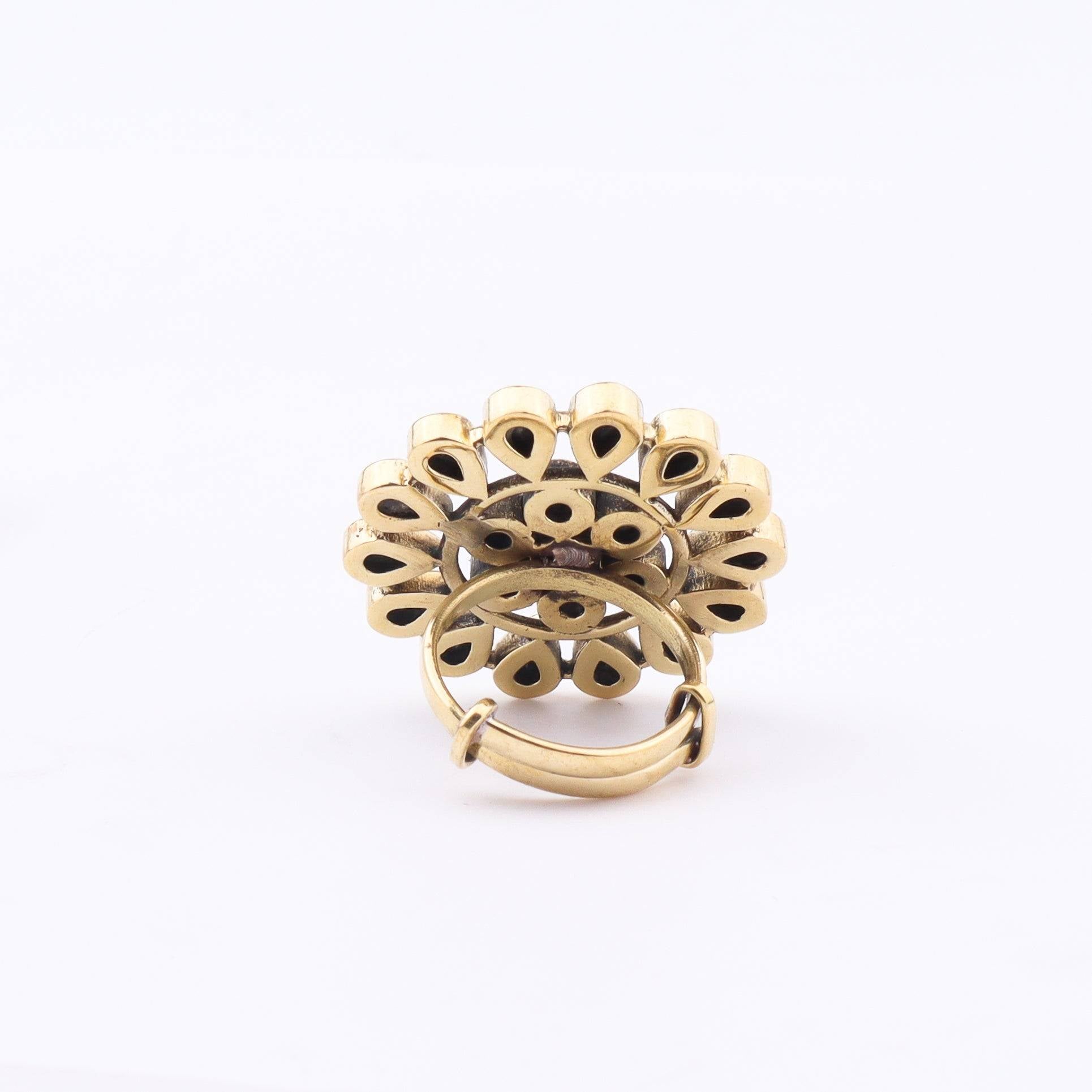 Angled view of a brass fashion ring highlighting its distinctive shape, structure, and polished brass finish
