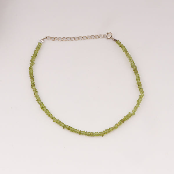 Close-up of green peridot beaded anklet on ankle