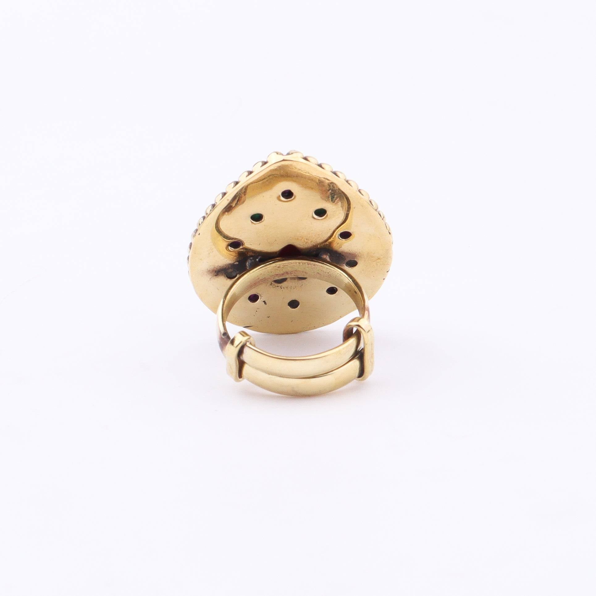Angled view of a brass fashion ring highlighting its distinctive shape, structure, and polished brass finish