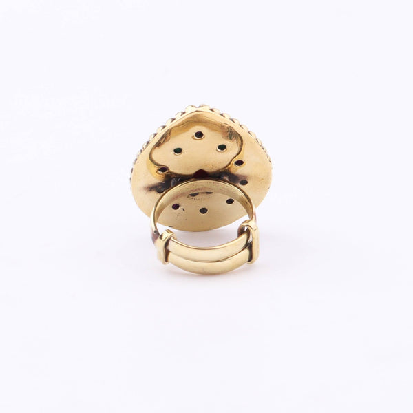 Angled view of a brass fashion ring highlighting its distinctive shape, structure, and polished brass finish