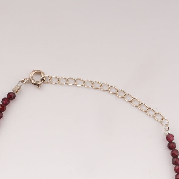 Silver chain with garnet beads anklet on white background