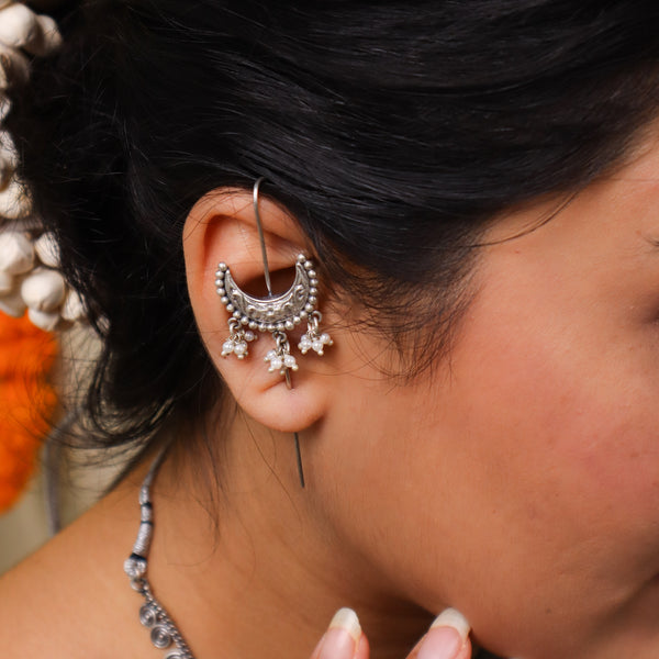 Silver earrings with intricate design and dangling pearl accents