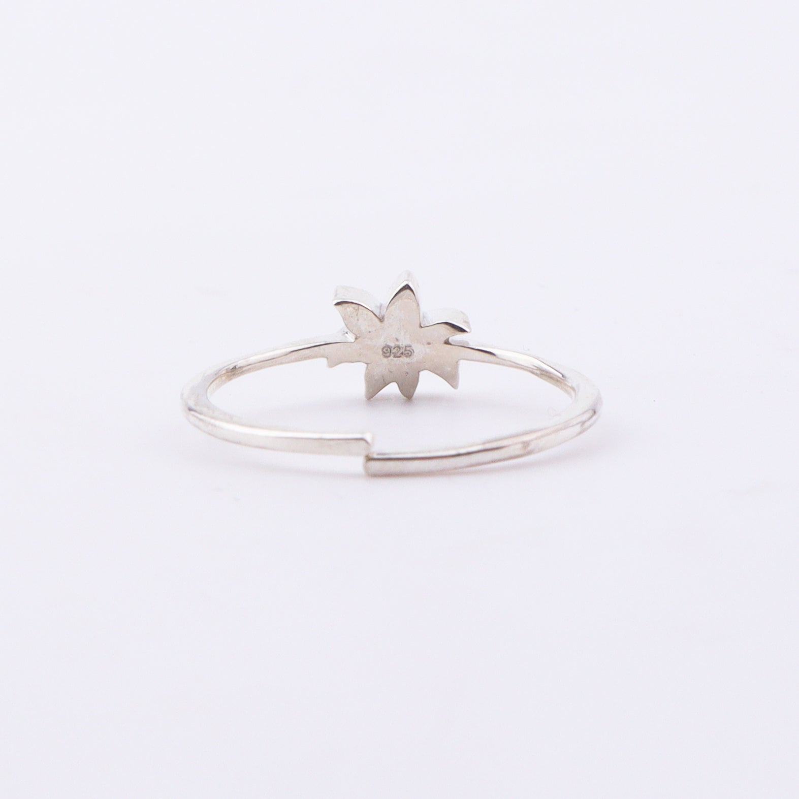 Close-up of White Lily enamel ring on finger