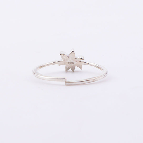 Close-up of White Lily enamel ring on finger