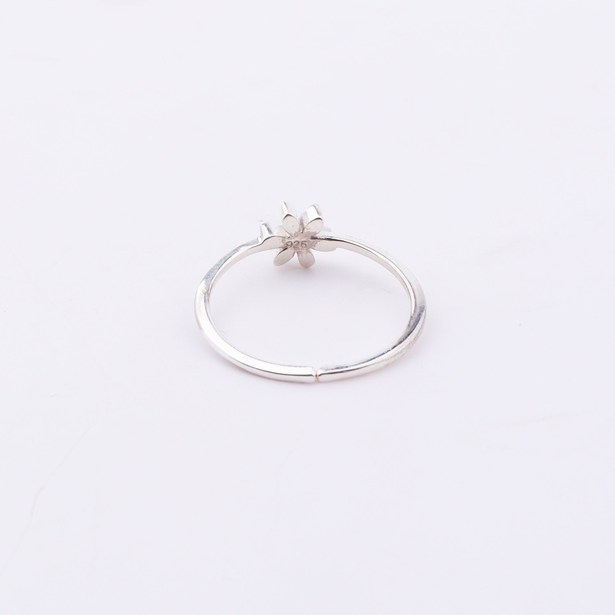 Side view of silver flower ring with red enamel