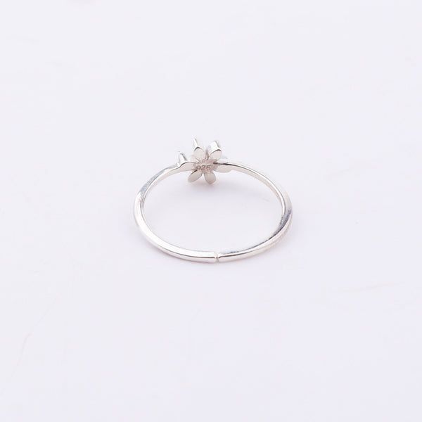 Side view of silver flower ring with red enamel