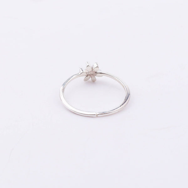 Side view of silver flower ring with red enamel