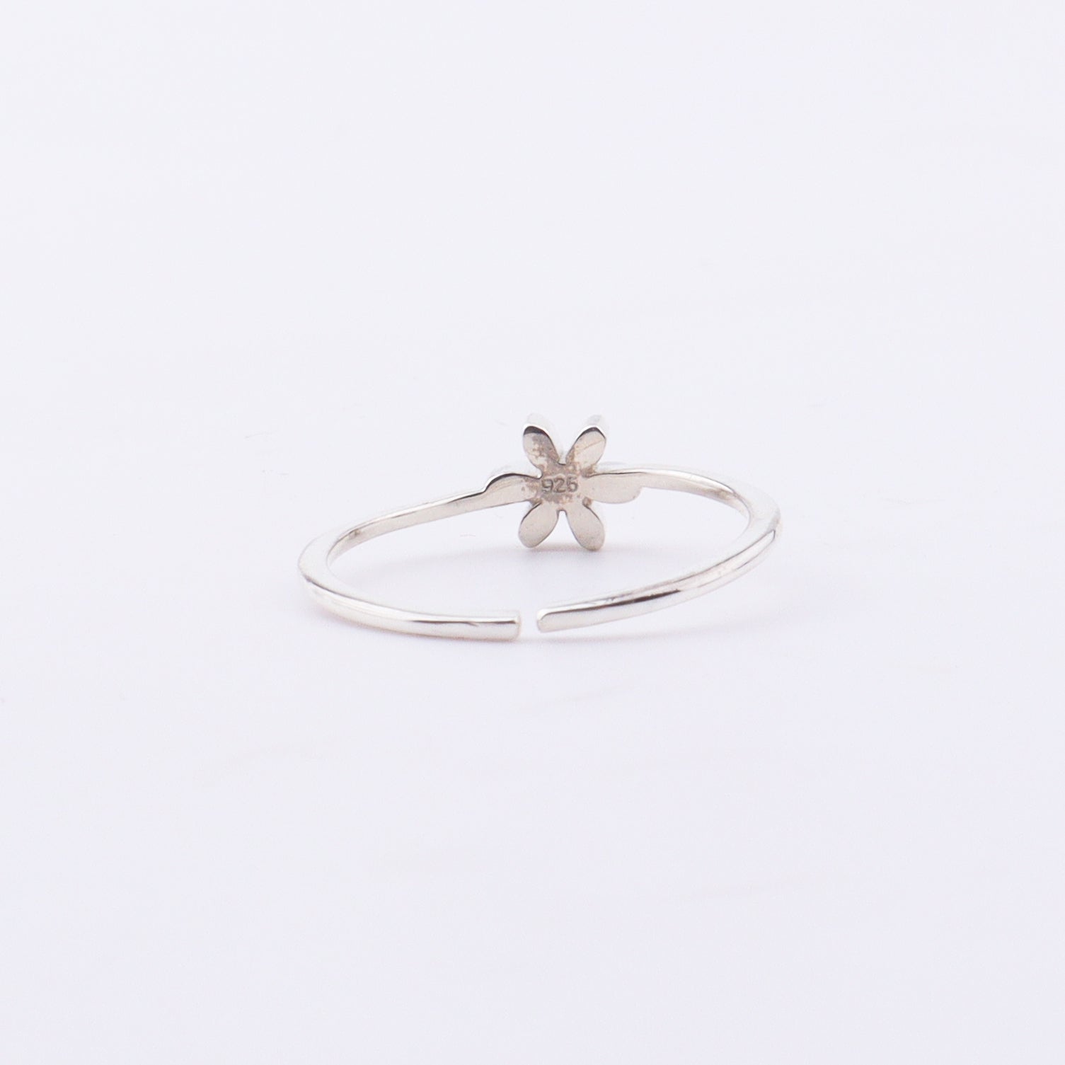 Close-up of white flower enamel ring on finger