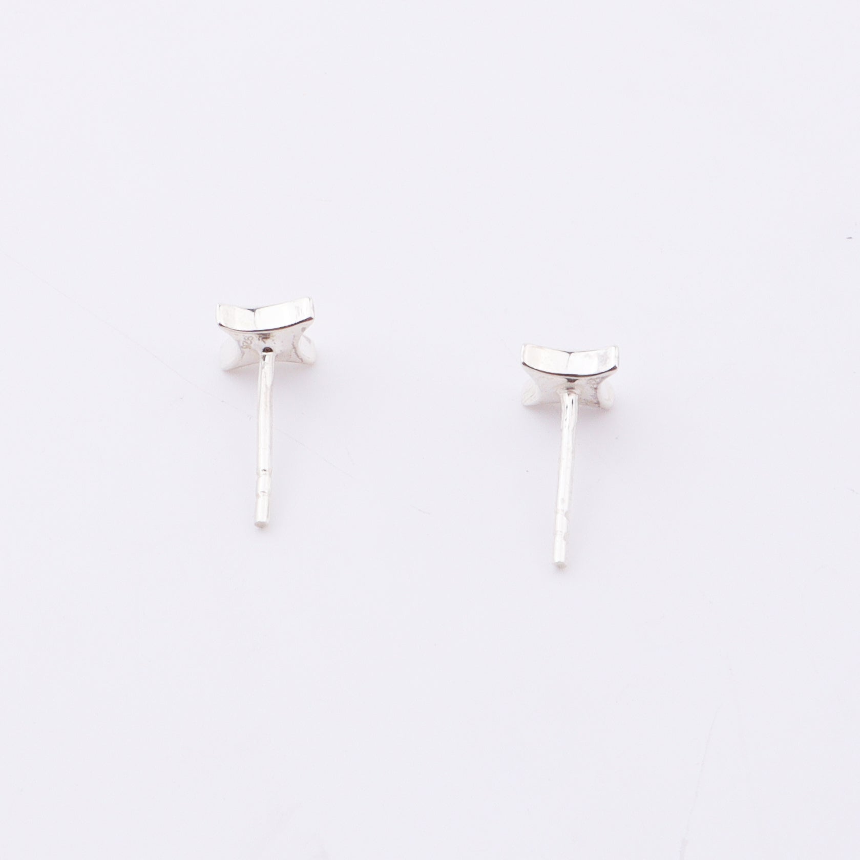 Sterling silver star enamel stud earrings on white background, jewelry detail