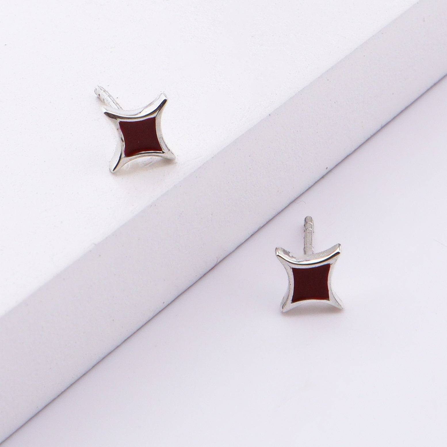 Close-up of star enamel stud earrings in sterling silver, jewelry display