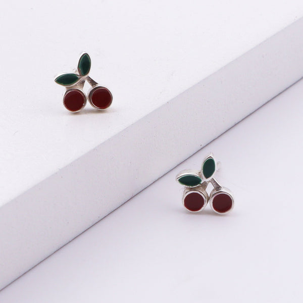 Close-up of cherry enamel earrings on white background