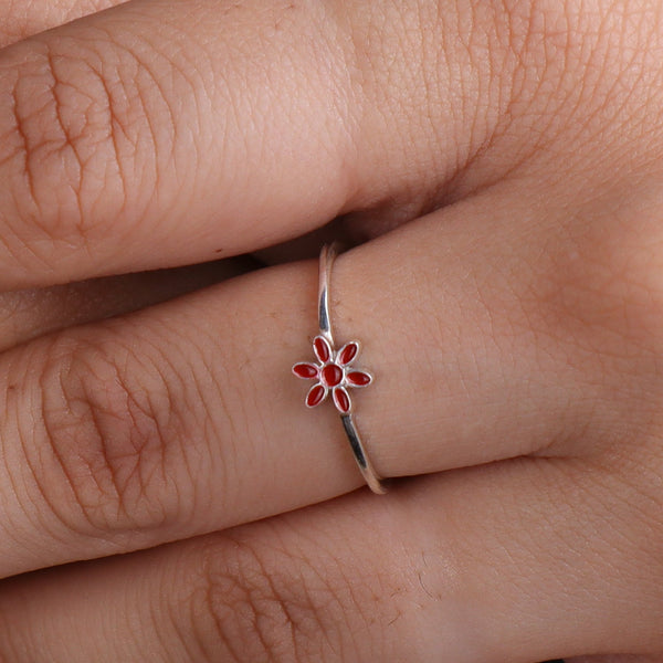 Silver flower ring with red enamel on finger