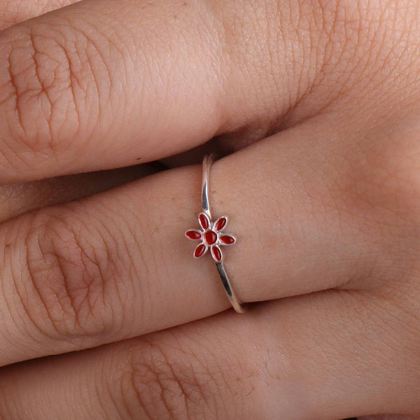 Silver flower ring with red enamel on finger