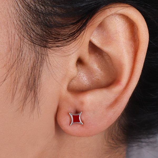 Woman wearing star enamel stud earrings, close-up of ear jewelry