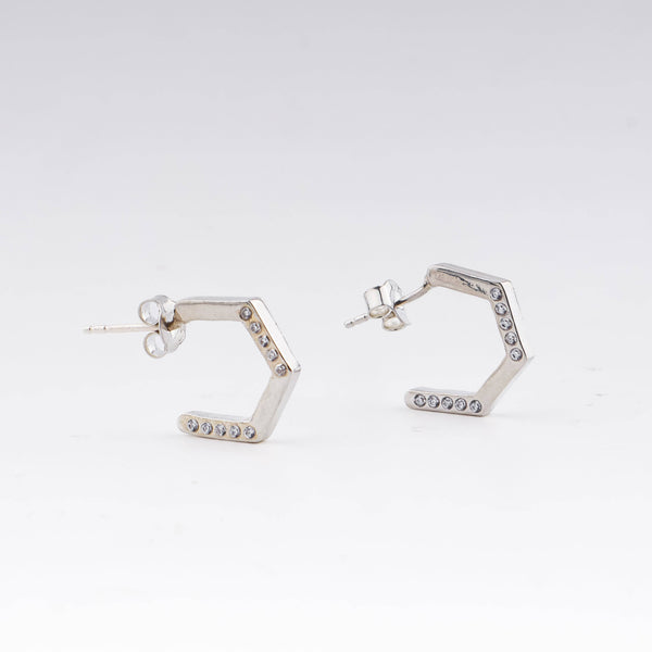 Silver hexagon hoop earrings with CZ stones on white background